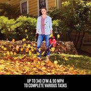 Photo of Craftsman CMCK197M1 leaf blower in use outdoors, blowing autumn leaves in a garden setting.