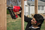 Photo of Craftsman cordless nailer CMCN630PTB in use against wooden framing outdoors.
