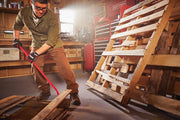 Photo of Craftsman CMHT82500 red pry bar being used to dismantle wooden pallets in a workshop.