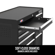 A black multi-drawer tool chest with one drawer open, showing soft-close mechanism and drawer liner. The tool chest features a USA flag sticker and a Craftsman logo. Text on the image reads: 'Soft-close drawers, drawer liners included.'