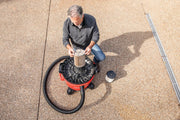 Photo of person installing a filter in a Craftsman wet/dry vacuum, SKU CMXEVBE17595, outdoors on pavement.