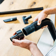 Photo of CRAFTSMAN vacuum hose adapter CMXZVBE38665 with accessory attachments on wooden table.